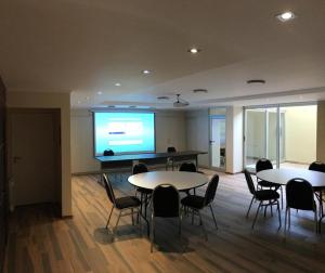 una sala de conferencias con 2 mesas y una pantalla grande en SanPier - Alquileres Temporarios en Allen