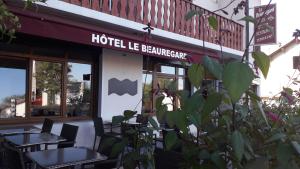 un restaurant avec des tables et des chaises en face d'un bâtiment dans l'établissement Hotel Le Beauregard, à Divonne-les-Bains