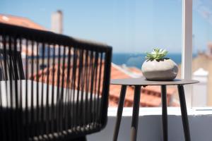 a plant sitting on top of a table on a balcony at Reserva FLH Hotels Ericeira in Ericeira