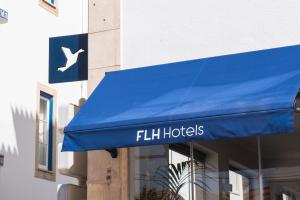 a blue awning on the side of a building at Reserva FLH Hotels Ericeira in Ericeira