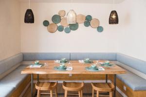 a wooden table with chairs and plates on it at Reserva FLH Hotels Ericeira in Ericeira