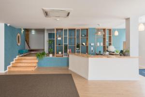 a lobby with blue walls and a counter with plants at Reserva FLH Hotels Ericeira in Ericeira