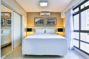 a hotel room with a bed and a window at Golden Tulip Goiania Address in Goiânia