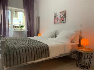 a bedroom with a bed with a blanket and a window at Santo Amaro Apartment in Lisbon