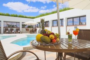 a bowl of fruit on a table next to a pool at Golden Tulip Goiania Address in Goiânia