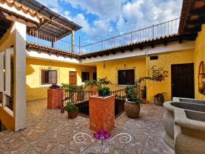 a courtyard of a yellow building with potted plants at Maison Bougainvillea in Antigua Guatemala