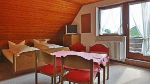 1 dormitorio con 1 cama, mesa y sillas en Grüner Hof, en Zell am Harmersbach