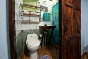 a small bathroom with a toilet and a sink at Hotel Sunshine Caribe in Puerto Viejo