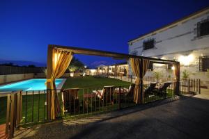 a patio with a fence and a swimming pool with curtains at Casa Rural Alma Del Tajo, Toledo, Puy Du Fou in Albarreal de Tajo