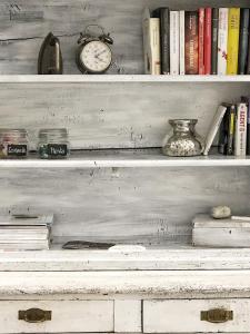 une étagère avec des livres et une horloge dans l'établissement Picinque B, à Côme