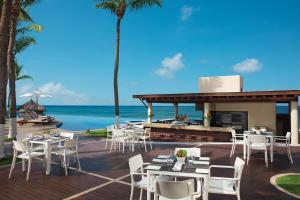 un restaurante en la playa con mesas y sillas en Krystal Grand Nuevo Vallarta en Nuevo Vallarta 
