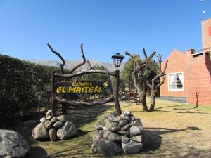 una señal para el cartel de El Marín y algunas rocas en Cabañas El Maiten en Merlo