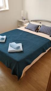 a large bed with two towels on top of it at Apartments Blue House in Korčula