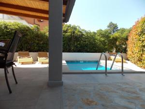 een zwembad met een tafel en een stoel ernaast bij Apartment with private pool in Njivice