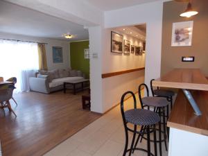 een woonkamer met een bar, stoelen en een bank bij Apartment with private pool in Njivice