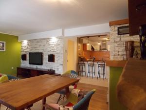 een woonkamer met een houten tafel en een keuken bij Apartment with private pool in Njivice