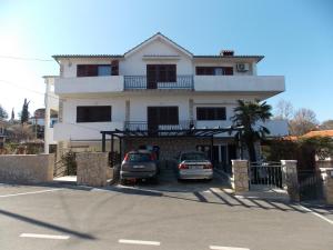 een huis met twee auto's ervoor geparkeerd bij Apartment with private pool in Njivice