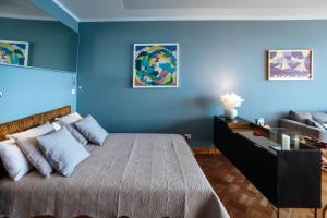 Dormitorio azul con cama y sofá en Promenade des Anglais - Studio suite seaside, en Niza