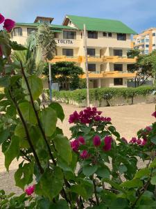Hostal La Tolita في أتاكاميس: مبنى أمامه ورد وردي