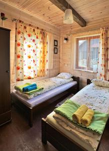 a bedroom with two beds in a wooden cabin at Mazury-dom in Świętajno