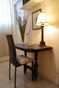 a table with a lamp and a chair with a lamp at Borgo Antico Santa Lucia in Potenza