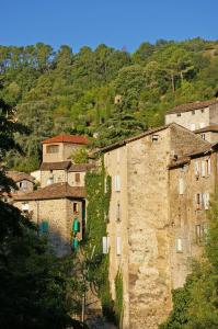 un groupe de bâtiments sur une colline plantée d'arbres dans l'établissement Les chambres Anglaises, à Largentière