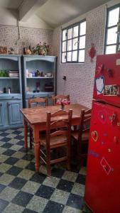 cocina con mesa de madera y nevera roja en Casa Reina Palermo Queens en Buenos Aires