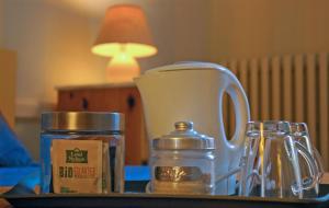 - une table avec une cafetière et un pot en verre dans l'établissement Les chambres Anglaises, à Largentière