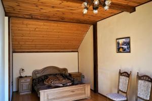 a bedroom with a bed and a wooden ceiling at Котедж Гірський in Yaremche