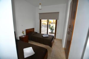 een kleine kamer met een bed en een spiegel bij Villa Trachonas in Pissouri