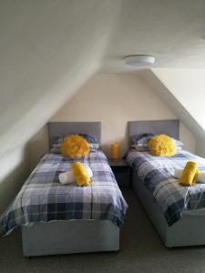two beds with teddy bears on them in a attic at Mortlach Cottage in Dufftown