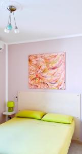 een slaapkamer met een bed met een schilderij aan de muur bij Casa vacanze Salento in Diso
