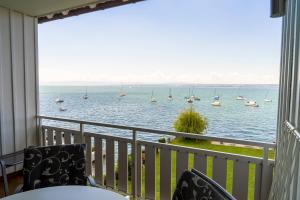 a balcony with a view of the water with boats at Gasthaus Seeblick in Hagnau