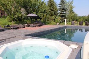 a hot tub in a yard next to a swimming pool at Magtár Vendégház Harsány in Harsány