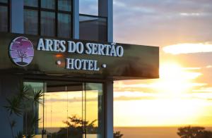 a sign on the side of a building with the sunset at Hotel Ares do Sertão in Chapada Gaucha