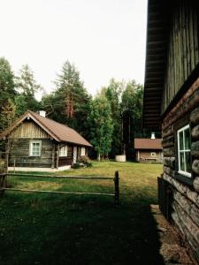 une cabane en rondins avec une clôture en face d'une cour dans l'établissement Ligedama Wabatalu, à Koljaku