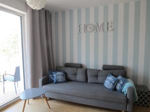 una sala de estar con sofá y un cartel que lee a casa en Apartamenty Siesta-Family SPA en Kołobrzeg