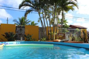 - une piscine dans une cour avec des palmiers dans l'établissement Casa Pousada Rosa dos Ventos, à Florianópolis