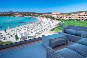 a balcony with couches and a view of a beach at Appartamento delfini sul mare in Golfo Aranci