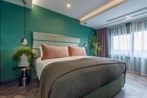 a bedroom with a large bed with a green wall at Waterfront Southport Hotel in Southport