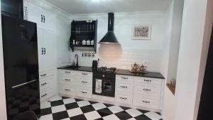 een keuken met een zwart-wit geruite vloer bij Apartament Twarda in Warschau