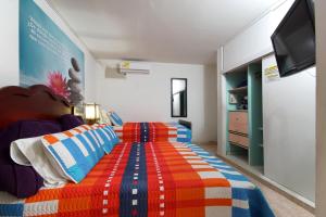 een slaapkamer met een bed met een kleurrijke deken bij Hostal Tequendama Martha Santamaria in Cali