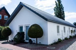 een wit huis met een zwart dak bij EngholmBB in Odense