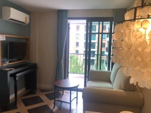 un salon avec un canapé, une table et une télévision dans l'établissement Espana Condo Resort Pattaya EVT, à Jomtien Beach