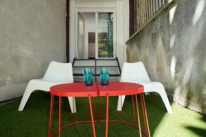 two red tables and two white chairs with blue glasses on them at Tulum Apart Belgrade in Belgrade