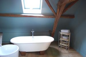 baño con bañera blanca y ventana en Rubbensloft en Zele