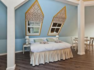 1 Schlafzimmer mit blauen Wänden und 1 Bett mit 2 Fenstern in der Unterkunft Cathedral Prague Apartments in Prag