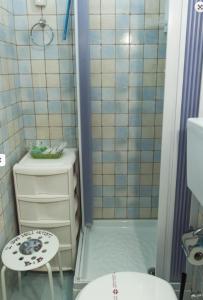 a bathroom with a shower and a toilet and a stool at Il Covo degli Artisti in Campobello di Licata