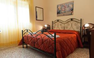 a bedroom with a bed with a red blanket and a window at Il Covo degli Artisti in Campobello di Licata