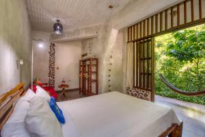 A bed or beds in a room at Omega Tours Eco-Jungle Lodge